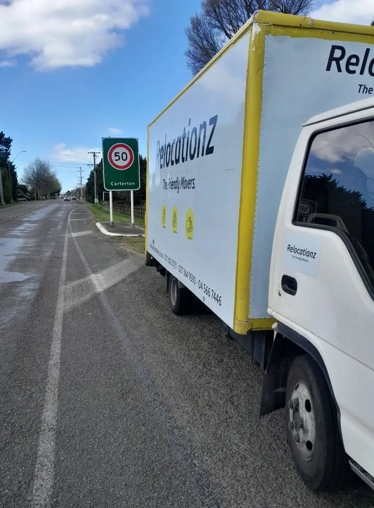 RelocatioNZ truck on the open road at the Carterton town boundary