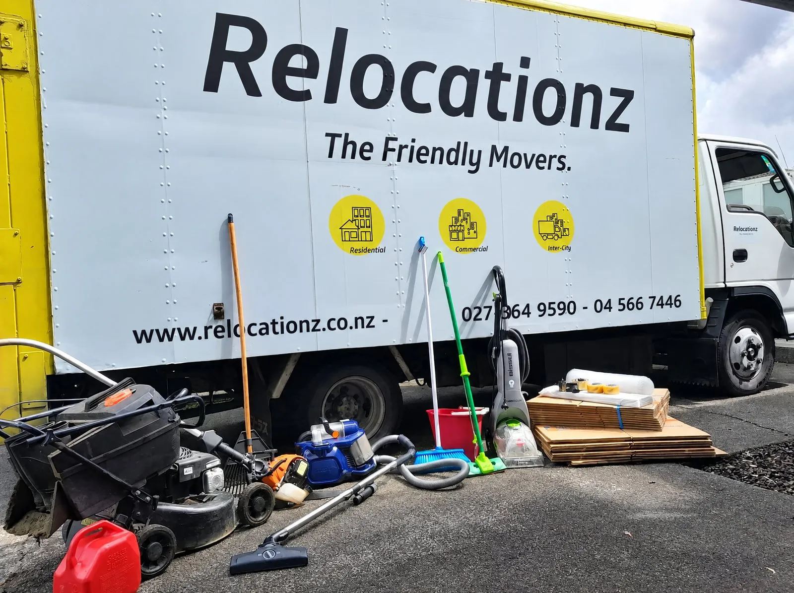 Mower, vacuum and garden gear on the kerb beside the RelocatioNZ truck, ready to load