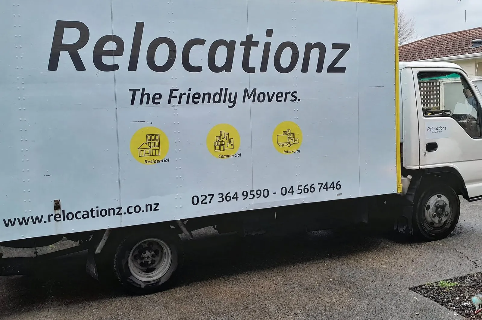 RelocatioNZ truck parked on a Wellington street, branding and phone numbers along the side